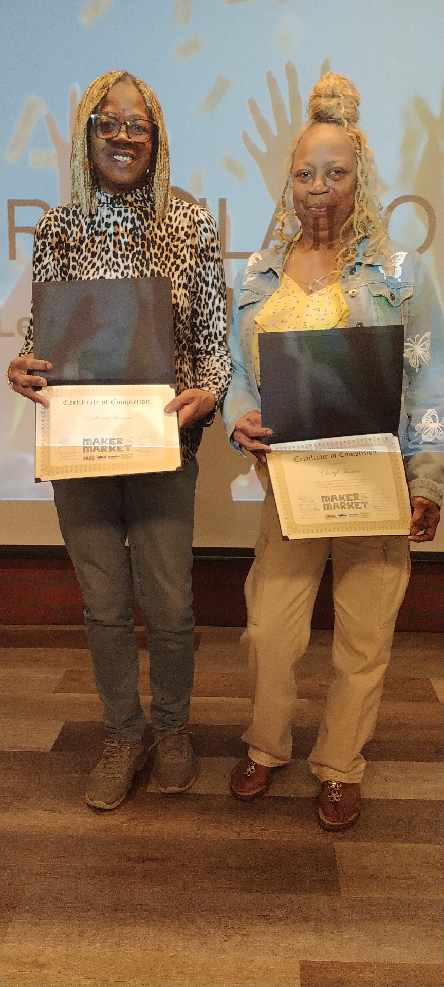 Deborah Turner and her sister holding their Maker to Market certificates of completion